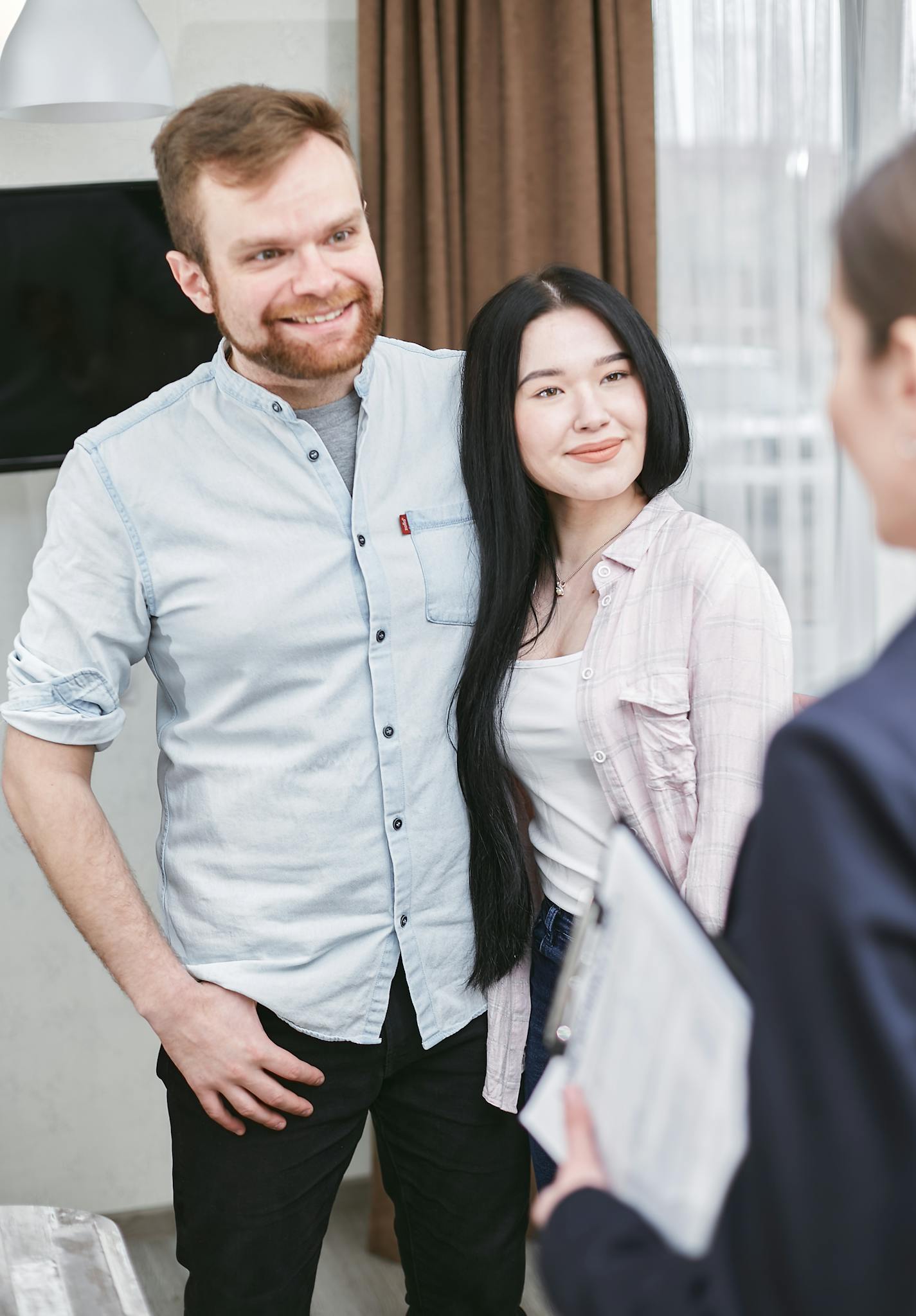Smiling couple meeting with an advisor indoors, in a professional setting.